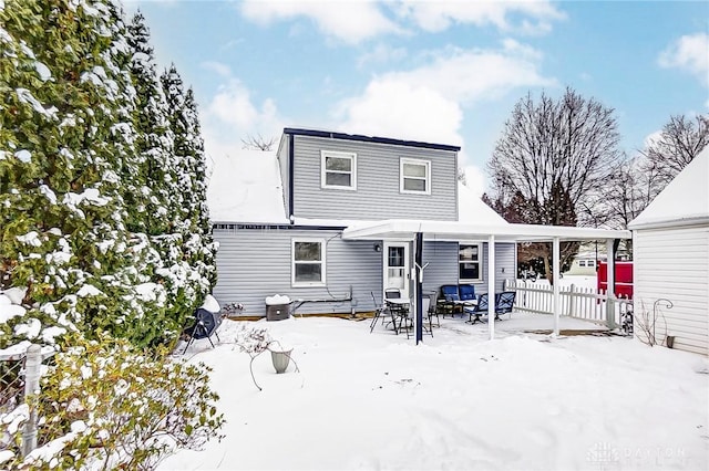 view of snow covered back of property