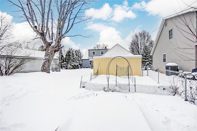 snowy yard with an outbuilding and central AC