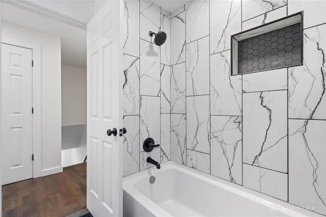 bathroom with wood-type flooring and tiled shower / bath