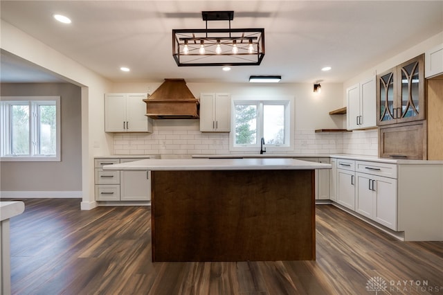 kitchen featuring pendant lighting, custom exhaust hood, and white cabinets