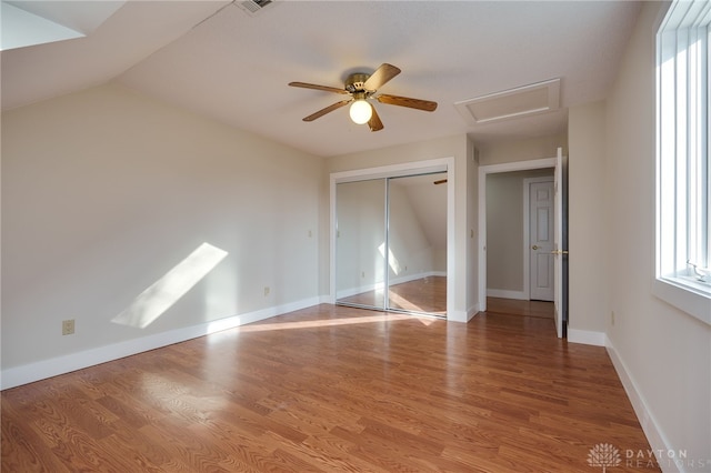 unfurnished bedroom with ceiling fan, a closet, light hardwood / wood-style floors, and lofted ceiling