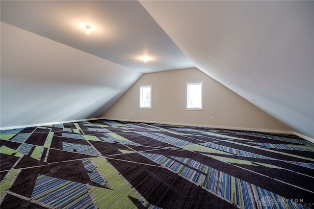 unfurnished bedroom featuring carpet flooring and vaulted ceiling