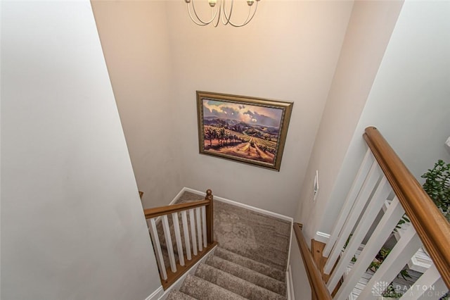 staircase featuring carpet and an inviting chandelier