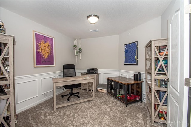 carpeted office with a textured ceiling