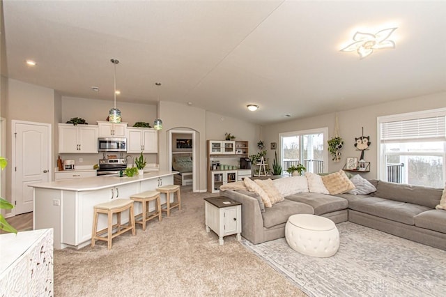 living room with light carpet and vaulted ceiling