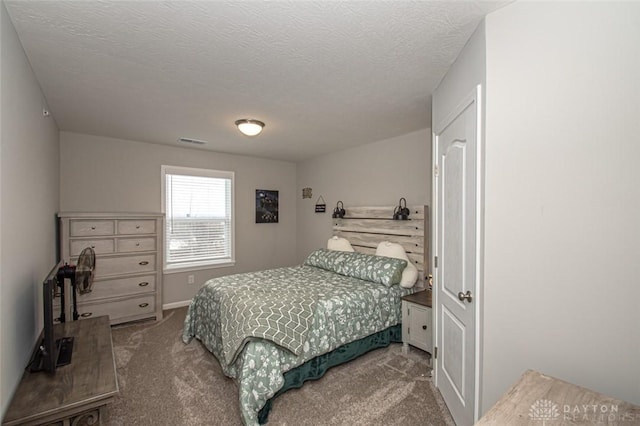 bedroom featuring a textured ceiling and carpet floors