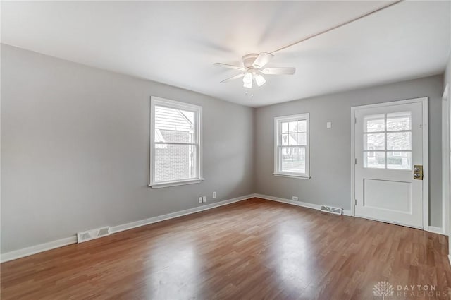 spare room with hardwood / wood-style floors, ceiling fan, and a healthy amount of sunlight