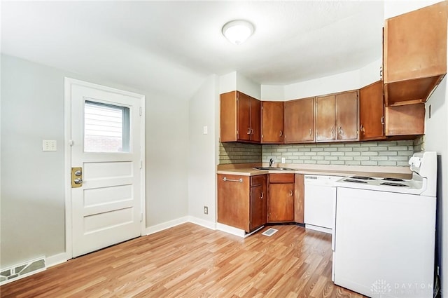 kitchen featuring sink, white appliances, light hardwood / wood-style flooring, and backsplash