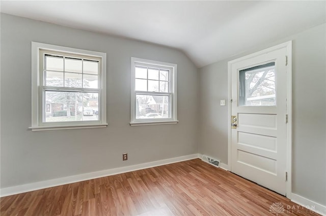 entrance foyer featuring light hardwood / wood-style floors and vaulted ceiling