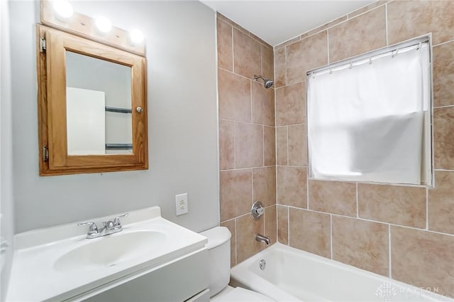 full bathroom featuring vanity, toilet, and tiled shower / bath