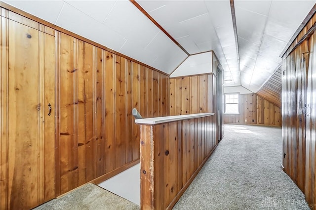 additional living space with light carpet, wooden walls, and lofted ceiling