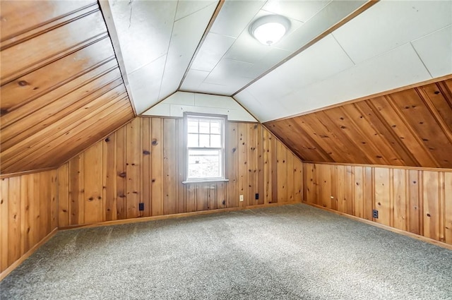 additional living space with carpet, wood walls, and vaulted ceiling