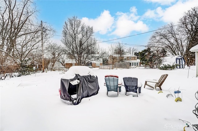 yard layered in snow featuring a shed