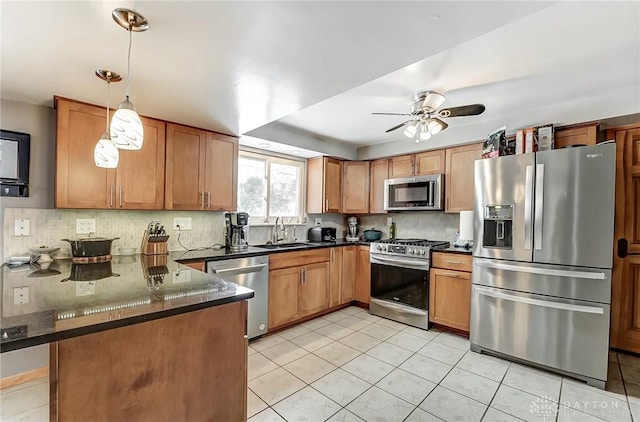 kitchen with sink, backsplash, hanging light fixtures, kitchen peninsula, and stainless steel appliances