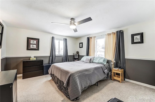 carpeted bedroom featuring multiple windows, a textured ceiling, and ceiling fan