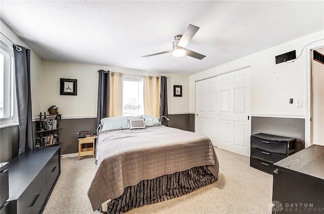 carpeted bedroom with ceiling fan and a closet