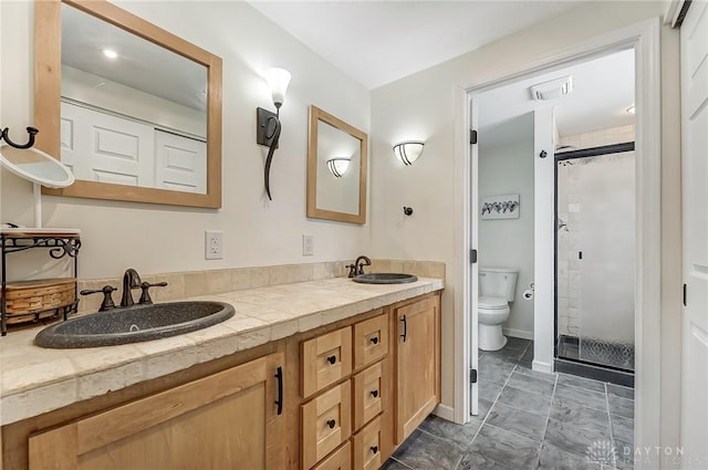 bathroom featuring vanity, an enclosed shower, and toilet