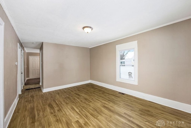 empty room with crown molding and hardwood / wood-style floors