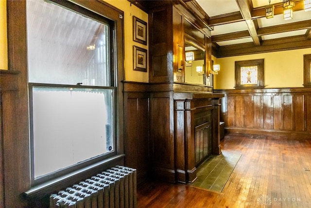 bar with dark hardwood / wood-style flooring, radiator, coffered ceiling, beam ceiling, and decorative light fixtures