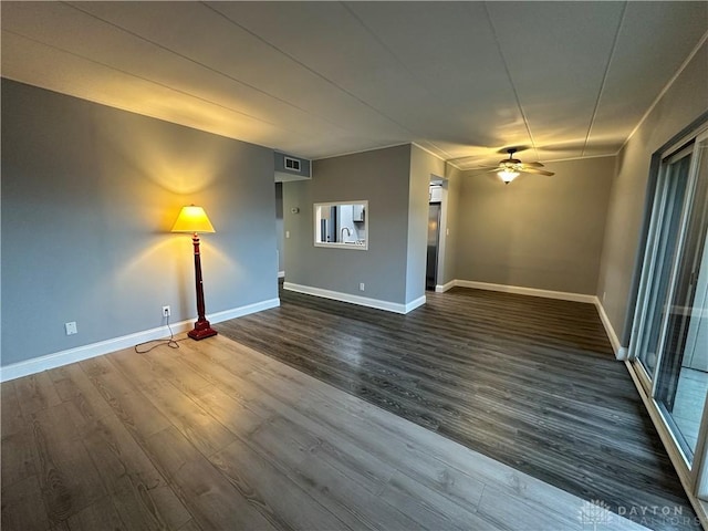 unfurnished living room featuring ceiling fan, sink, and dark hardwood / wood-style floors