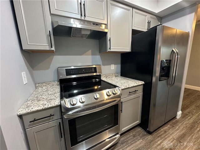 kitchen with light stone countertops, appliances with stainless steel finishes, dark hardwood / wood-style floors, and gray cabinetry