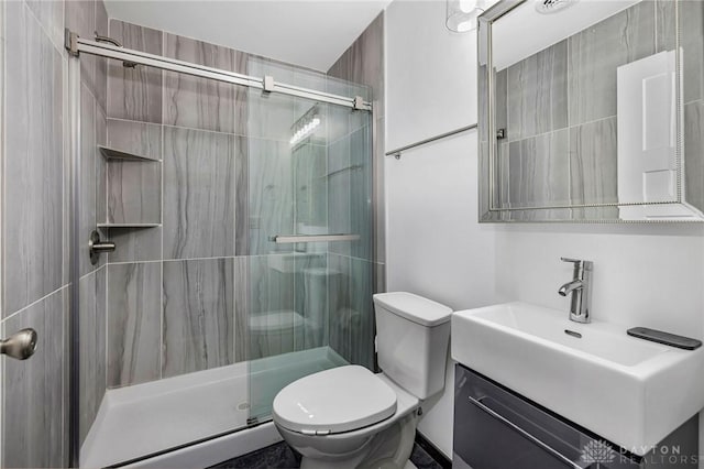 bathroom with vanity, toilet, and a shower with shower door