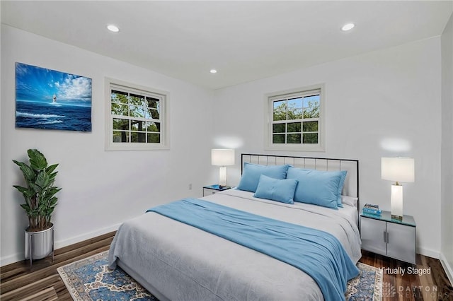 bedroom with multiple windows and dark wood-type flooring