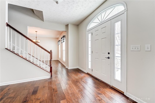 entrance foyer with a healthy amount of sunlight, dark wood-type flooring, and a textured ceiling