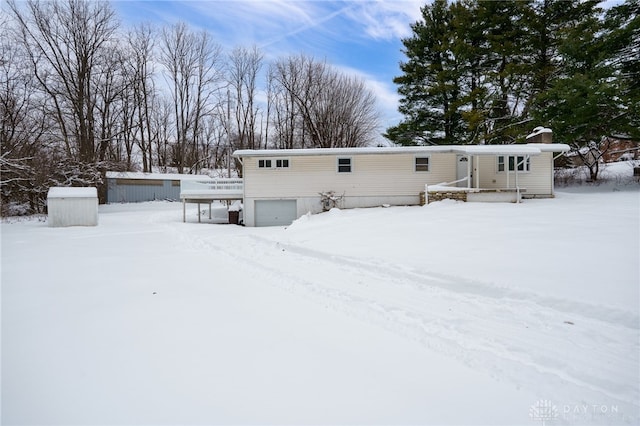 view of snow covered back of property