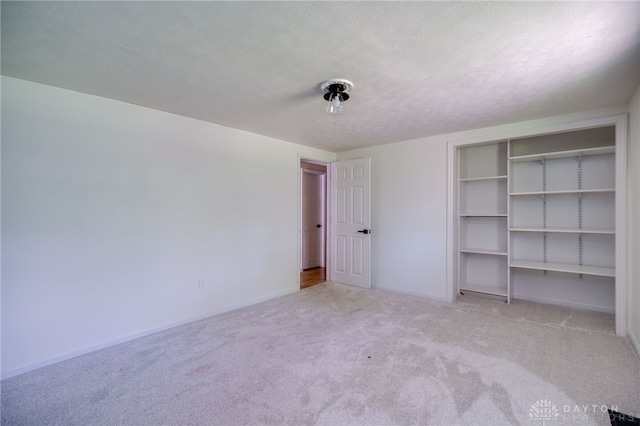 unfurnished bedroom featuring carpet floors, baseboards, and a closet