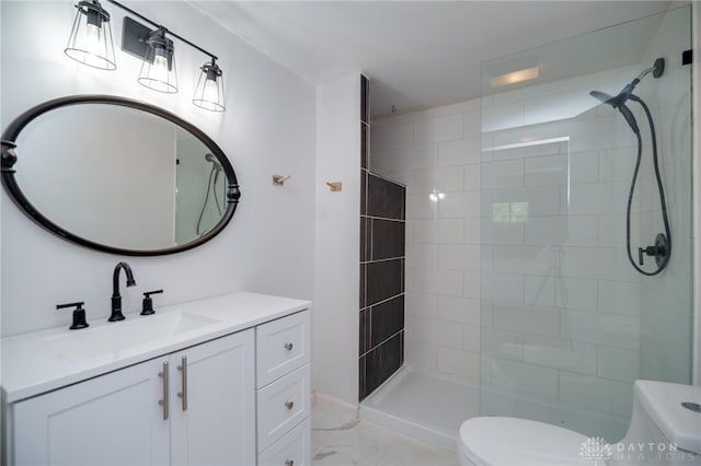 bathroom with toilet, a tile shower, marble finish floors, and vanity