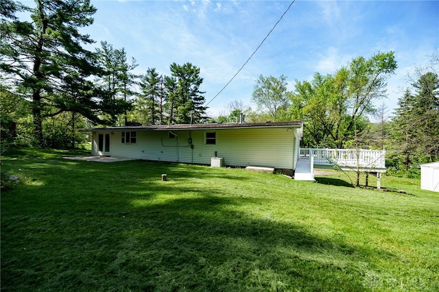 back of house with a wooden deck and a lawn