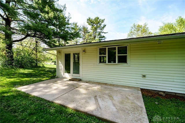 back of property featuring a patio and a lawn