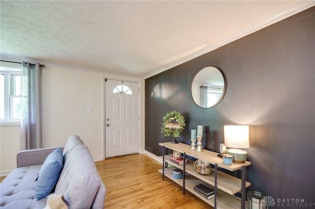 foyer entrance featuring light wood finished floors, baseboards, and ornamental molding
