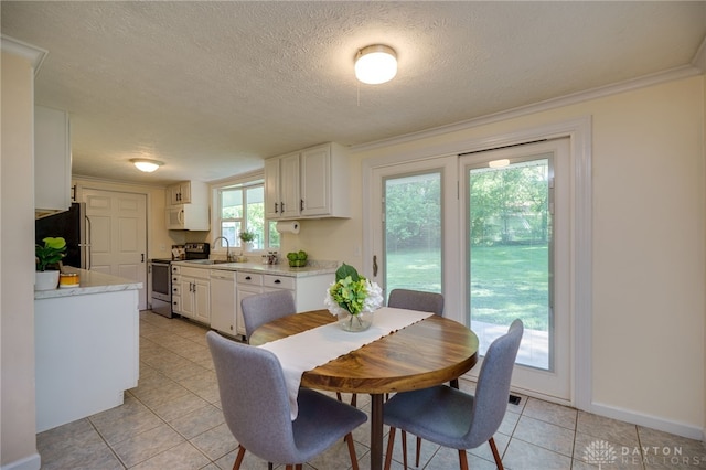dining room with light tile patterned flooring, a textured ceiling, baseboards, and ornamental molding