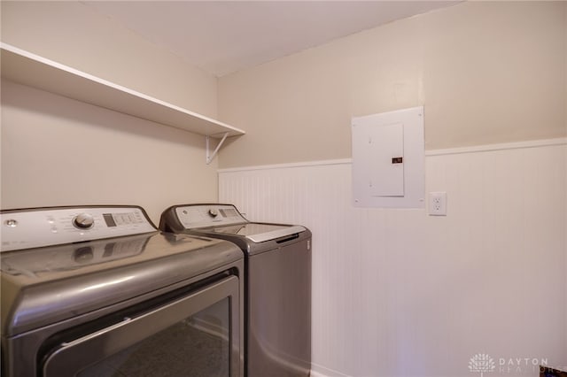 washroom with a wainscoted wall, independent washer and dryer, and electric panel