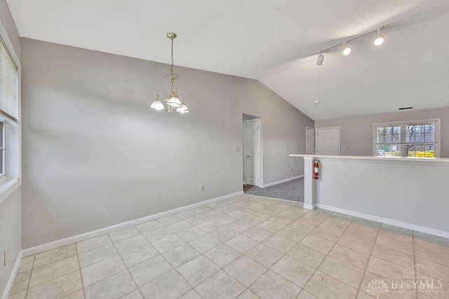 unfurnished room with light tile patterned floors, an inviting chandelier, and lofted ceiling