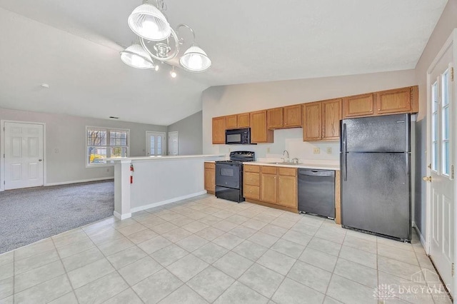 kitchen with pendant lighting, black appliances, sink, vaulted ceiling, and light colored carpet