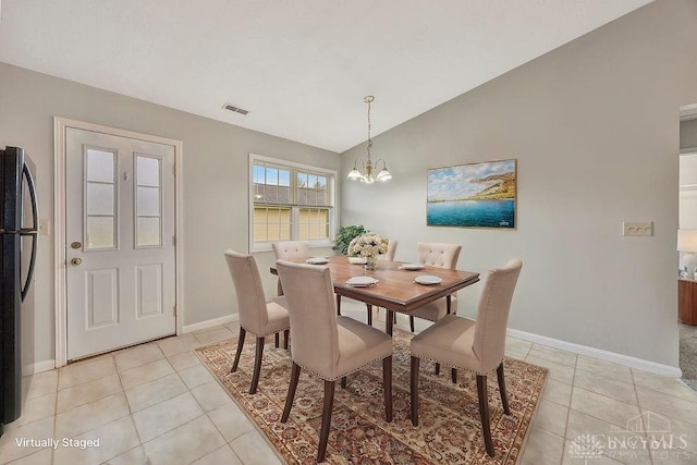 tiled dining space with lofted ceiling and an inviting chandelier