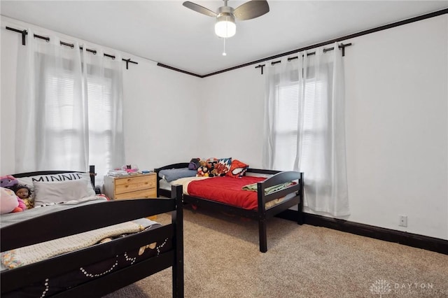 bedroom with ceiling fan, carpet floors, crown molding, and multiple windows