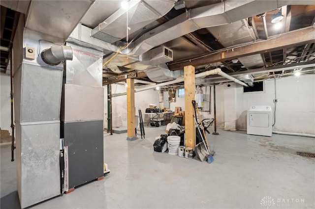 basement featuring washer / dryer, electric panel, and heating unit