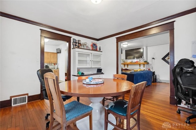 dining area featuring crown molding and hardwood / wood-style floors