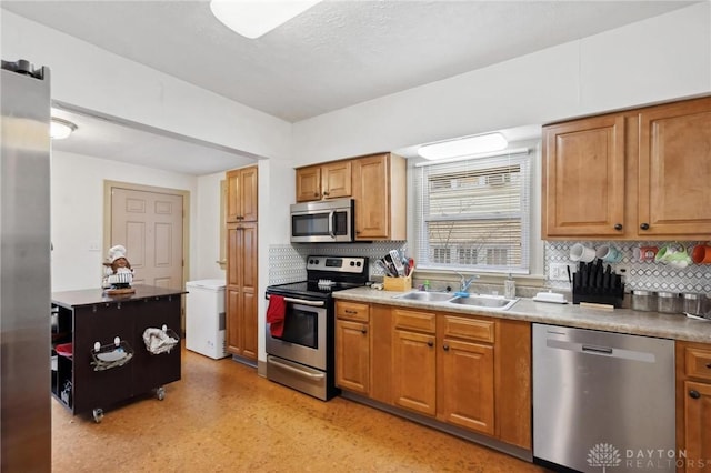 kitchen featuring backsplash, sink, and appliances with stainless steel finishes