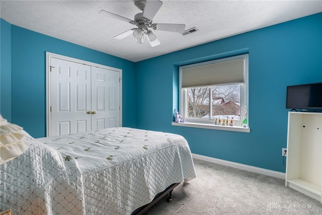 bedroom with carpet, ceiling fan, a textured ceiling, and a closet