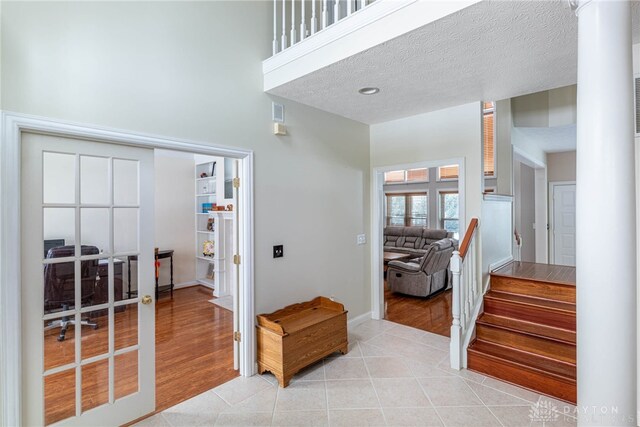 interior space featuring french doors, tile patterned flooring, and a textured ceiling