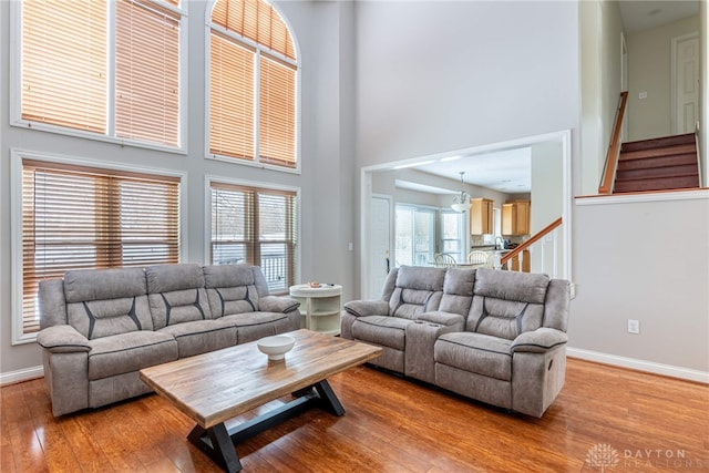 living room featuring hardwood / wood-style flooring, a high ceiling, and a chandelier