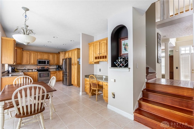 kitchen featuring decorative backsplash, stainless steel appliances, sink, pendant lighting, and light tile patterned flooring