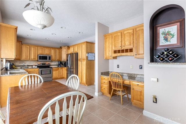 kitchen featuring sink, hanging light fixtures, stainless steel appliances, decorative backsplash, and light tile patterned floors