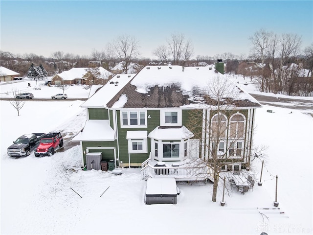 snow covered house with a wooden deck