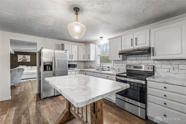 kitchen with stainless steel appliances, white cabinetry, decorative light fixtures, and under cabinet range hood